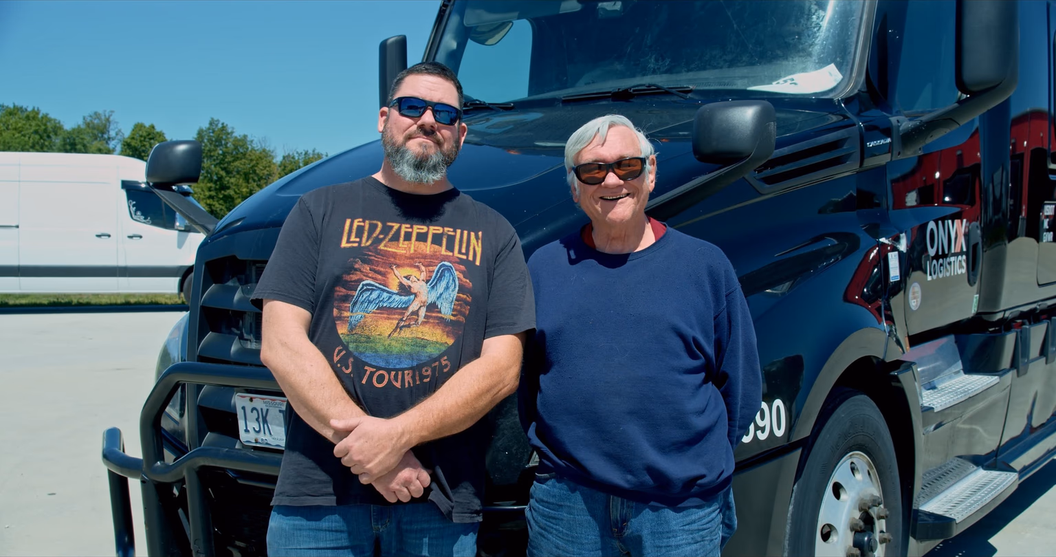 Jerry and Jeff Clites, a father-and-son driving team at Onyx Logistics, standing together in front of an Onyx tractor at the Strafford, Missouri yard.