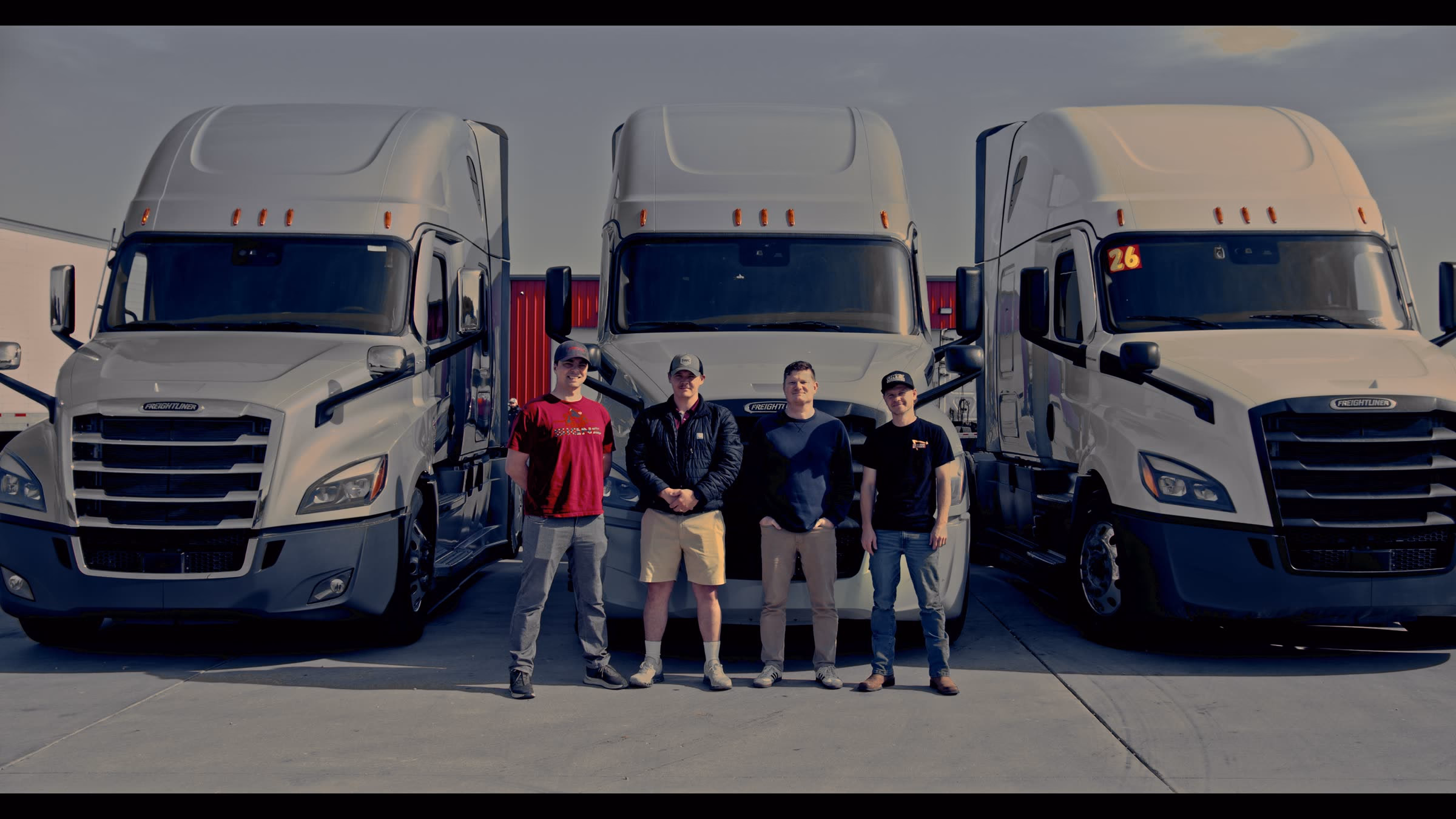 The Onyx Logistics team standing together in front of three Freightliner tractors at the Strafford, Missouri yard.